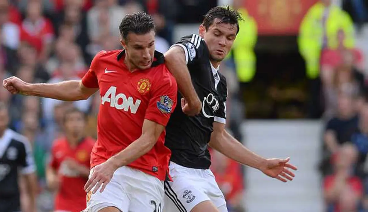 Striker Manchester United Robin Van Persie (kiri) duel dengan bek Southampton Jos Hooiveld pada pertandingan sepak bola Liga Premiere Inggris di Old Trafford, Manchester (13/10/19). (AFP/Andrew Yates)