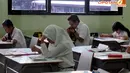 Para siswa SMA 112 Jakarta terlihat serius mengerjakan soal-soal ujian nasional pada Senin (14/4/2014). (Liputan6.com/Johan Tallo)