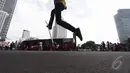 Seorang remaja mencoba trik lompat dengan skateboard di kawasan Bundaran HI Jakarta, Minggu (14/12/2015). (Liputan6.com/Faizal Fanani)
