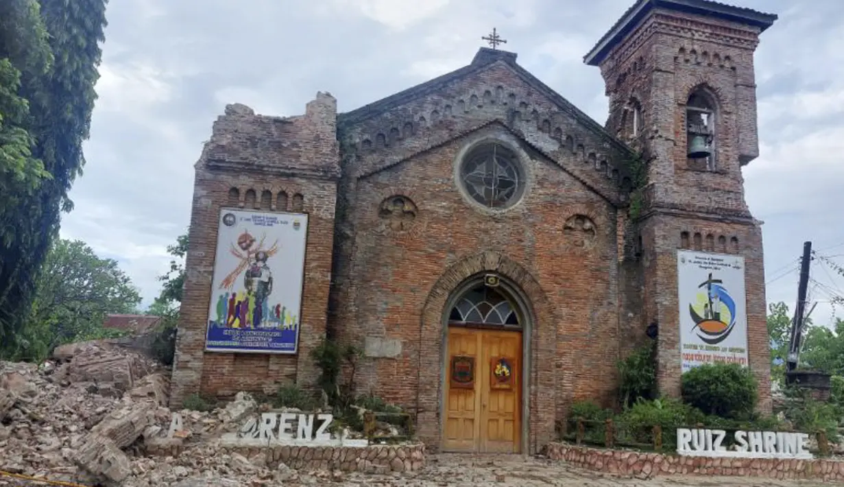 Puing-puing dari salah satu menara Gereja San Lorenzo Ruiz berjatuhan ke tanah setelah gempa kuat melanda Bangued, Provinsi Abra, Filipina, 27 Juli 2022. Gempa yang menewaskan beberapa orang tersebut juga memicu tanah longsor dan merusak sejumlah bangunan. (AP Photo)