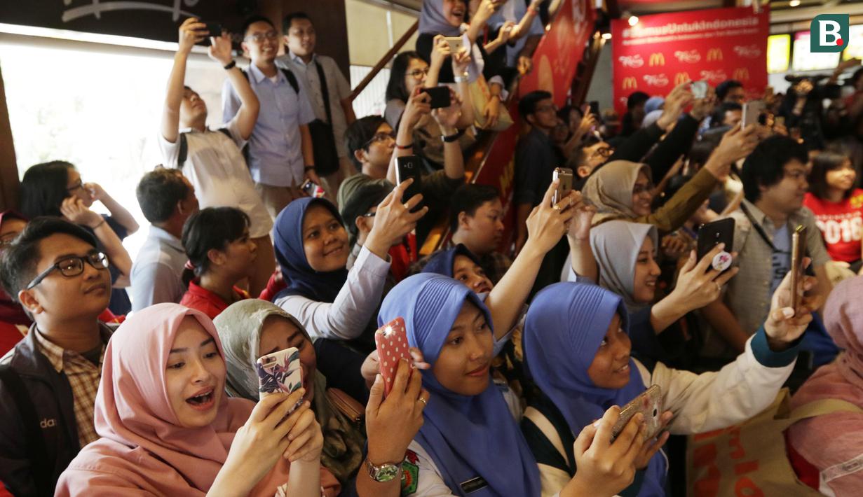 Para fans memotret peraih emas bulutangkis, Jonatan Christie, saat pemberian apresiasi di Sarinah, Jakarta, Rabu (5/9/2018). Peraih medali dari cabor bulutangkis dan wushu mendapat penghargaan berupa logam mulia. (Bola.com/M Iqbal Ichsan)