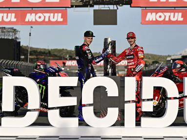 Pembalap Ducati, Francesco Bagnaia (kanan) dan pembalap Yamaha, Fabio Quartararo melakukan jabat tangan jelang seri terakhir MotoGP Valencia 2022 di Sirkuit Ricardo Tormo, Jumat (3/11/2022). (AFP/Javier Soriano)