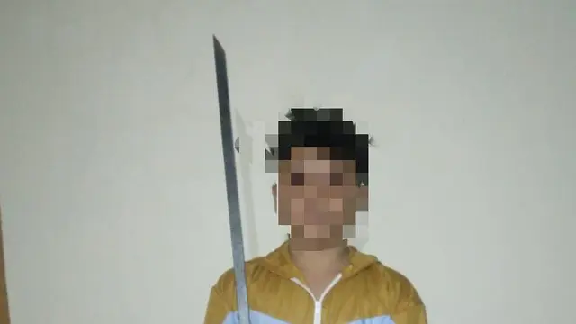 Afif Maulana berpose memegang pedang panjang. (Merdeka.com/Bachtiarudin Alam)