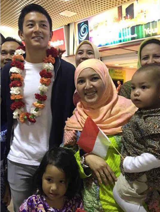 Warga Indonesia berfoto bersama pebalap Manor Racing asal Indonesia, Rio Haryanto, saat tiba di Bandar Udara Internasional Bahrain, Selasa (29/3/206). (Bola.com/Istimewa)