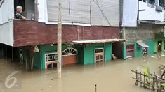  Warga menunggu banjir surut di kawasan Cawang, Jakarta, Selasa (21/2). Akibat curah hujan yang tinggi sejumlah pemukiman di bantaran Ciliwung kelurahan Cawang dan Rawajati terendam banjir. (Liputan6.com/Yoppy Renato)
