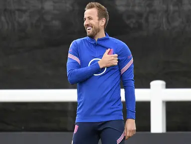 Striker timnas Inggris Harry Kane tertawa selama sesi latihan tim di St George's Park di Burton-upon-Trent, Senin (13/6/2022). Inggris akan bersua Hungaria pada matchday 4 Grup 3 UEFA Nations League A di Molineux Stadium, Rabu 15 Juni 2022 pukul 01.45 dini hari WIB. (Oli SCARFF / AFP)