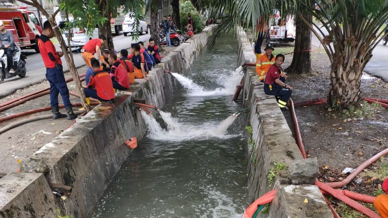 Petugas Damkar Surabaya menyedot genangan air. (Dian Kurniawan/Liputan6.com)