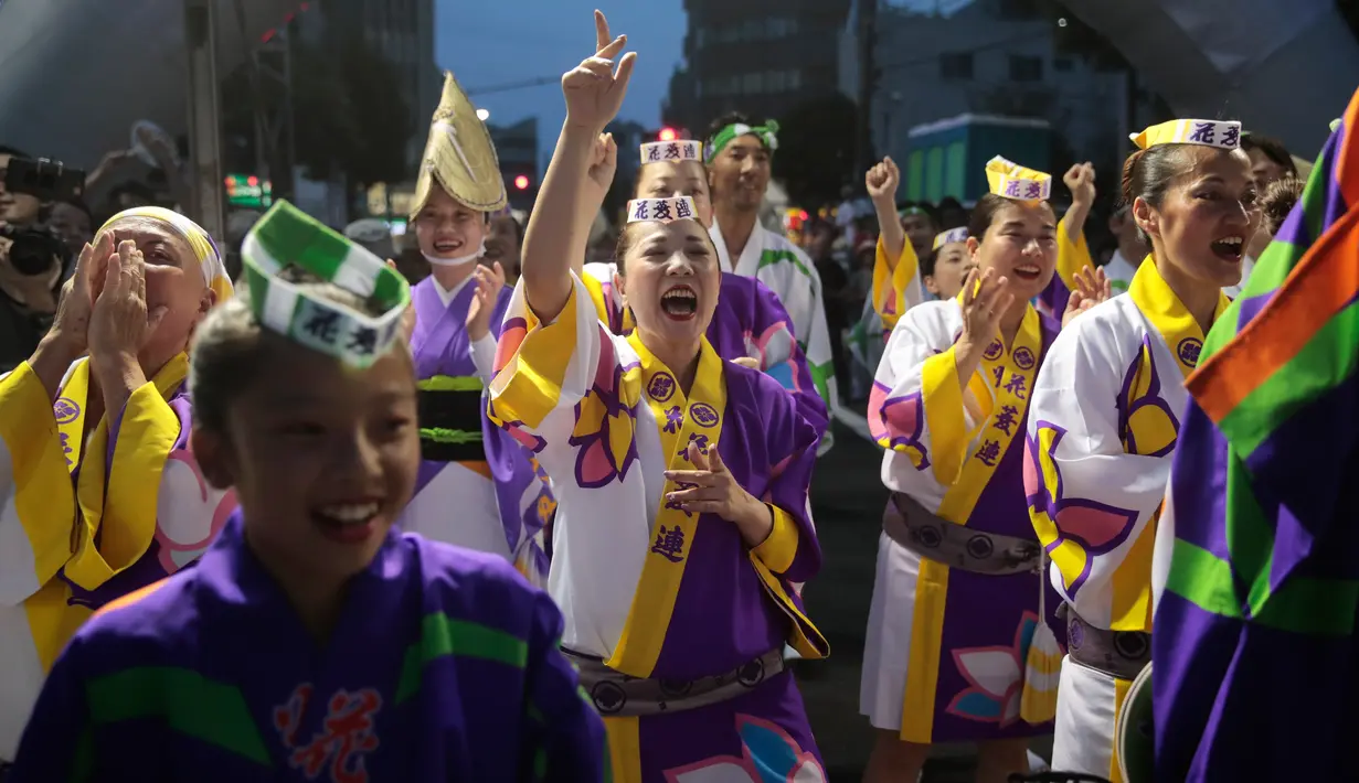 Penari bersorak ketika menyaksikan anggota tim mereka tampil selama festival tari Koenji Awa-Odori di kawasan Koenji, Tokyo pada 24 Agustus 2019. Ribuan orang menyaksikan tontonan musim panas yang diadakan pada akhir pekan terakhir bulan Agustus setiap tahun selama dua hari. (AP/Jae C. Hong)