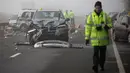 Petugas layanan darurat dikerahkan ke lokasi kecelakaan beruntun yang melibatkan sekitar 20 mobil di Oxfordshire, Inggris, Rabu (28/12). Satu orang perempuan meninggal dunia dan lebih dari 12 orang lainnya luka-luka. (AFP PHOTO/Daniel LEAL-OLIVAS) 