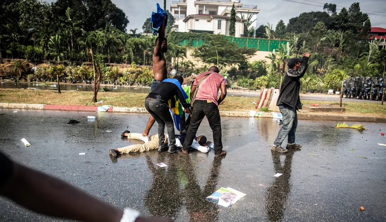 Seorang pendukung kandidat oposisi Gabon, Jean Ping, terluka dalam aksi bentrok dengan polisi anti huru hara di Ibu Kota Gabon, Libreville, Rabu (31/8). Aksi anarkis meletus setelah Presiden Gabon, Ali Bongo terpilih kembali. (MARCO LONGARI/AFP)