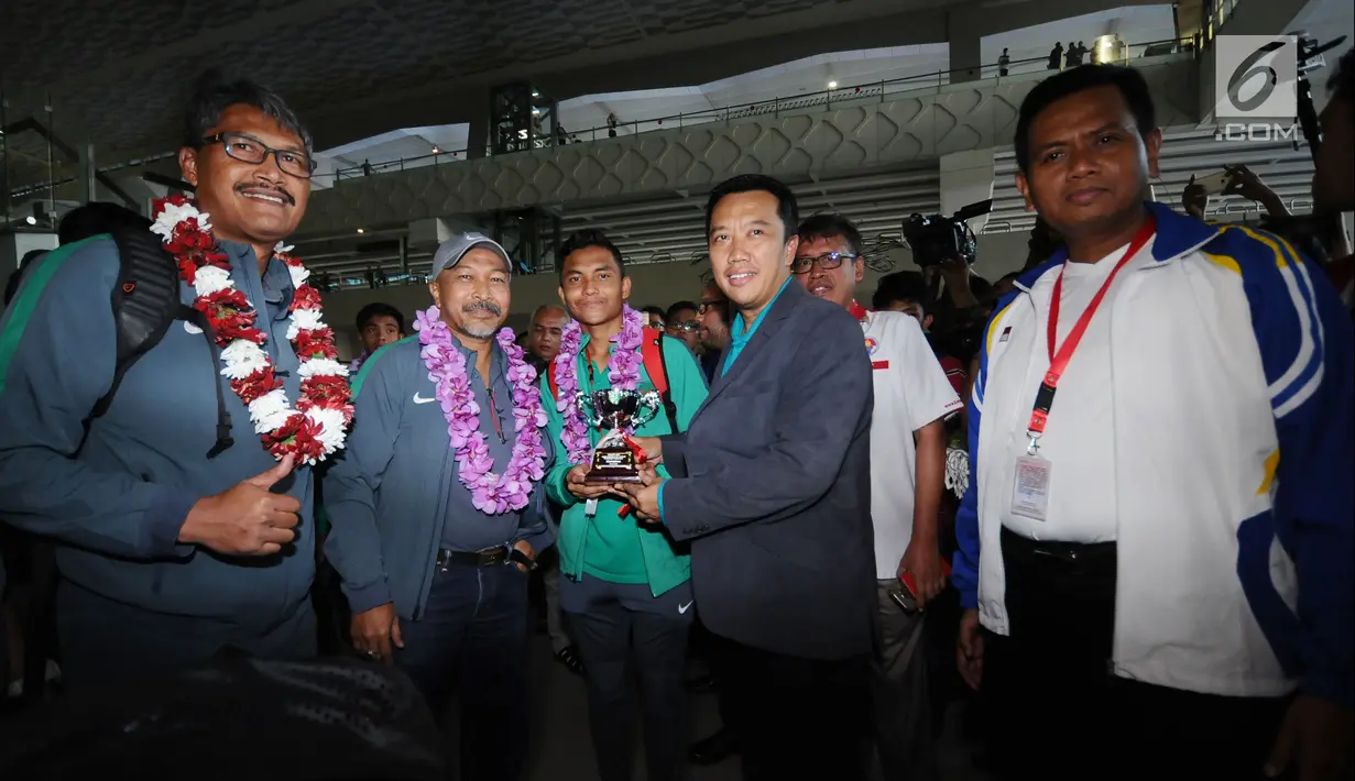 Menpora, Imam Nahrawi bersama pemain Timnas Indonesia U-16, Fadillah Nur Rahman dan pelatih Fakhri Husaini saat penyambutan di Bandara Soetta, Tangerang, Kamis (15/2). Timnas U-16 menjuarai turnamen Jenesys di Jepang. (Liputan6.com/Helmi Fithriansyah)