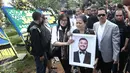 Ibunda Mike Mohede, Amin Yudhayani, memegang foto putranya dalam prosesi pemakaman di TPU Tanah Kusir, Jakarta, Selasa (2/8). Prosesi pemakaman Mike Mohede berjalan diiringi isak tangis keluarga, sahabat dan kekasihnya. (Liputan6.com/Herman Zakharia)