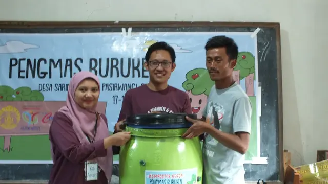 Ketua Tim Pengmas UI Astari Dwiranti dan Direktur Holistika Institute Cecep Ernanto, tengah memberikan drum kepada perwakilan warga, sebagai salah satu media pembuatan pupuk organik