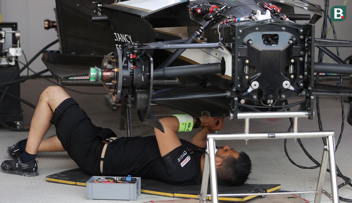 Mekanik tim Jaguar Tcs Racing mempersiapkan mobil jelang balapan Formula E di Sirkuit International E-Prix Circuit (JIEC), Ancol, Jakarta, Jumat (02/06/2023). (Bola.com/M Iqbal Ichsan)