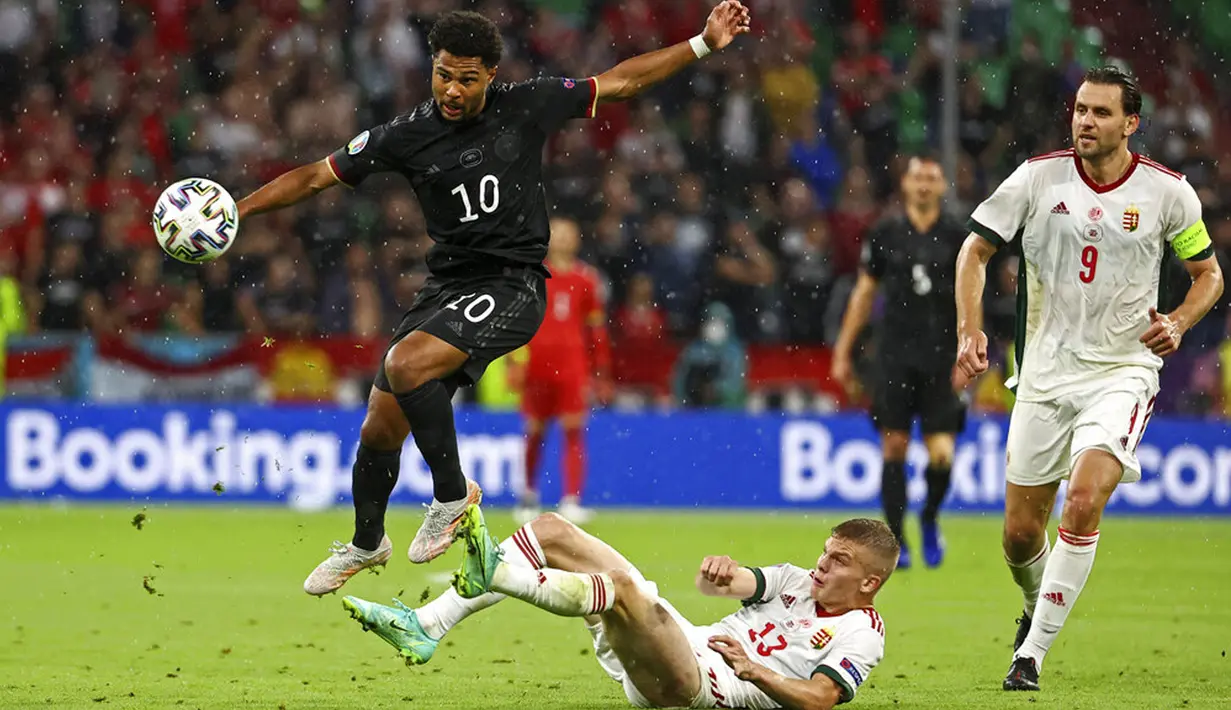 Pemain Jerman Serge Gnabry berebut bola dengan pemain Hungaria Andras Schaefer dari Adam Szalai pada pertandingan Grup F Euro 2020 di Allianz Arena, Munich, Jerman, Rabu (23/6/2021). Pertandingan berakhir imbang 2-2. (Kai Pfaffenbach/Pool via AP)