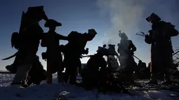 Penggemar sejarah mengenakan kostum tentara membakar api ungun saat beristirahat di Austerlitz, Republik Ceko (2/12). Pertempuran Austerlitz adalah salah satu dari sekian kemenangan besar yang diraih oleh Napoleon. (AP Photo/Petr David Josek)