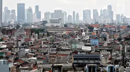 Pemandangan pemukiman padat penduduk dengan latar gedung bertingkat di Jakarta Pusat, Kamis (31/1). Populasi penduduk Jakarta yang mencapai 35,6 juta jiwa diperkirakan akan bertambah 4,1 juta orang antara 2017-2030. (Liputan6.com/Faizal Fanani)