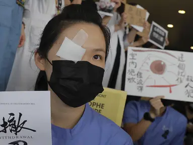 Seorang perawat mengenakan penutup mata dan masker mengambil bagian dalam protes terhadap kebrutalan polisi terhadap para pengunjuk rasa di sebuah rumah sakit di Hong Kong (13/8/2019). (AP Photo/Kin Cheung)