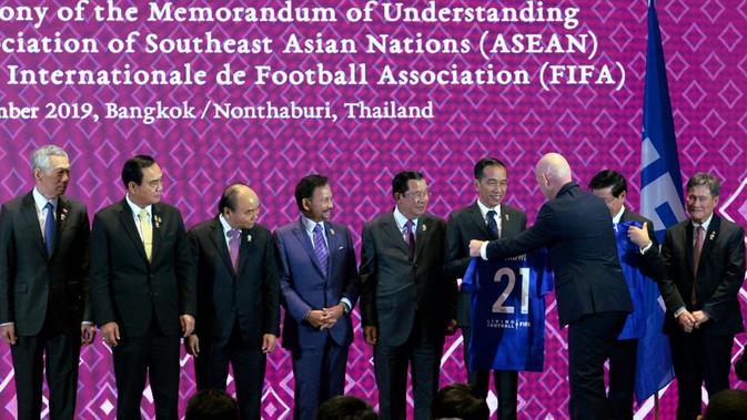 Presiden FIFA Gianni Infantino memberikan jersey nomor punggung 21 kepada Presiden Joko Widodo atau Jokowi pada acara penandatanganan MoU antara ASEAN dengan FIFA di Bangkok, Thailand, Sabtu (2/11/2019). (Liputan6.com/Biro Pers Setpres)