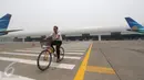 Petugas bersepeda di dekat hanggar terbesar di dunia milik PT Garuda Maintenance Facility di area Bandara Soekarno-Hatta, Tangerang, Senin (28/9). Pembangunan hanggar ini menelan biaya puluhan juta dolar AS.(Liputan6.com/Angga Yuniar)