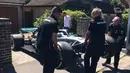 Sejumlah orang mengangkat mobil F1 dari Lewis Hamilton untuk bocah penderita kanker tulang langka Harry Shaw di Redhill, Surrey, Inggris, 13 Mei 2019. Setelah memenangi balapan F1 GP Spanyol, Lewis Hamilton mendedikasikan kemenangan yang diraihnya untuk Harry. (James Shaw/via REUTERS)