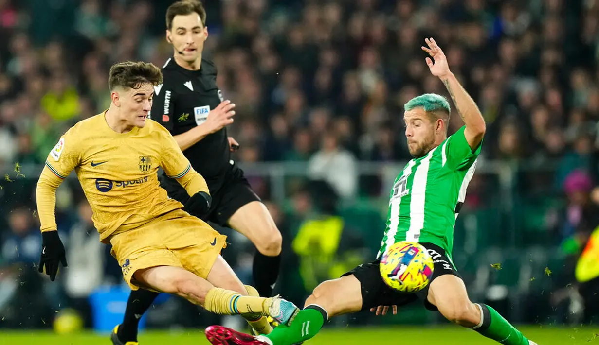 Pemain Barcelona Gavi (kiri) berebut bola dengan pemain Real Betis Aitor Ruibal pada pertandingan sepak bola Liga Spanyol di Stadion Benito Villamarin, Seville, Spanyol, 1 Februari 2023. Barcelona genap mengoleksi 50 poin dan unggul 8 poin dari Real Madrid usai menang 2-1 atas Real Betis pada lanjutan Liga Spanyol. (AP Photo/Jose Breton)