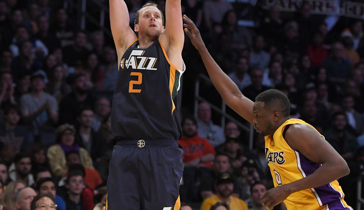 Pemain Utah Jazz,  Joe Ingles melakukan tembakan 3-poin saat dihadang pemain Los Angeles Lakers, Luol Deng pada laga NBA basketball game di Los Angeles, (27/12/2016).  (AP/Mark J. Terrill)