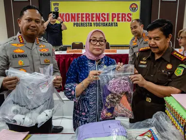 Menteri Pemberdayaan Perempuan dan Perlindungan Anak, Arifah Choiri Fauzi (tengah) memegang barang bukti terkait penyelidikan kasus pelecehan anak di salah satu pusat penitipan anak, Yogyakarta pada Senin 27 April 2026. (DEVI RAHMAN/AFP)