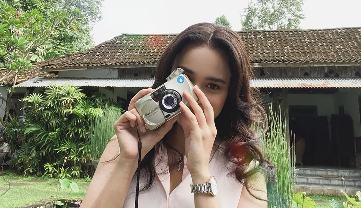Tidak hanya kamera DSLR, kamera yang menggunakan roll film nyatanya juga menjadi kesukaan Michelle Ziudith saat memotret. Gaya kecenya saat memotret ini bikin jatuh hati para penggemarnya. (Liputan6.com/IG/@michelleziu)