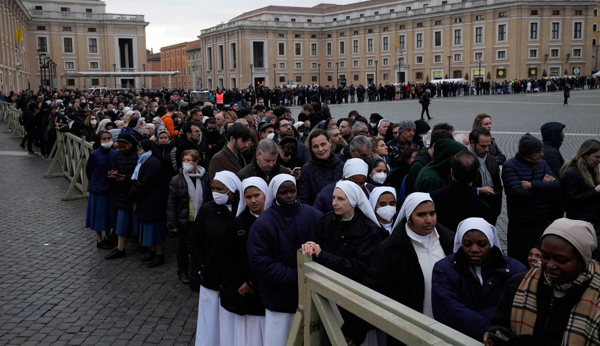 Orang-orang mengantre untuk memasuki Basilika Santo Petrus tempat mendiang Paus Emeritus Benediktus XVI disemayamkan di Vatikan, Senin (2/1/2023). Benediktus XVI, teolog Jerman yang akan dikenang sebagai paus pertama dalam 600 tahun yang mengundurkan diri, telah meninggal pada 31 Desember 2022 di usia 95 tahun. (AP Photo/Alessandra Tarantino)