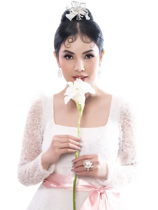 Rambutnya dibuat bun seperti Audrey yang ditambah hiasan kepala silver elegan. Serta poni wet melingkar. [@nindyayunda]