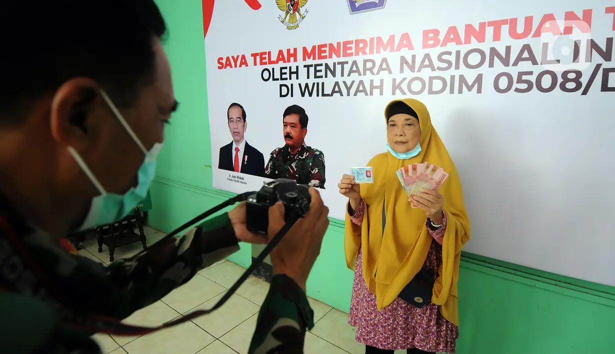Warga difoto usai mendapatkan Bantuan Tunai untuk Pedagang Kaki Lima dan Warung (BTPKLW) di Markas Kodim 0508/Depok, Jawa Barat, Rabu (20/10/2021). Bantuan diberikan kepada lebih dari 5.000 PKL dan pengusaha warung kecil. (merdeka.com/Arie Basuki)