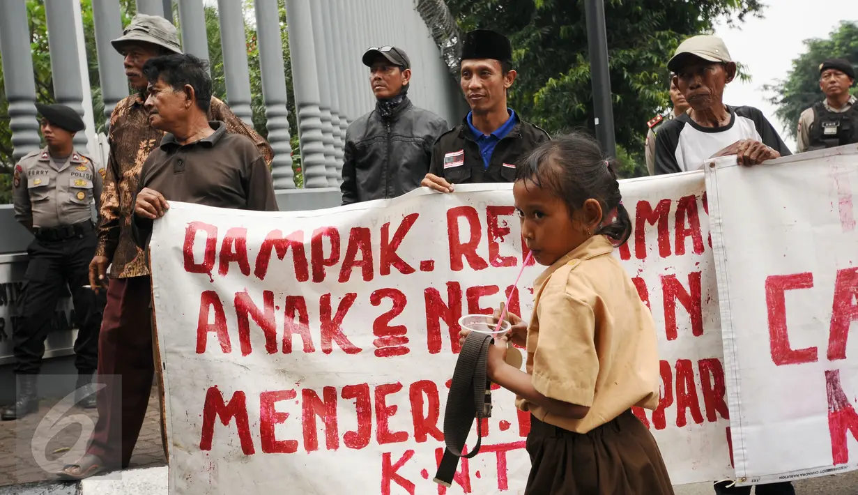 Seorang anak melintas di depan pengunjuk rasa di Kedubes Belanda di Jakarta, Rabu (23/11). Mereka meminta pemerintah Belanda menghentikan upaya mendorong investasi dalam pembangunan infrastruktur di Teluk Jakarta. (Liputan6.com/Helmi Fithriansyah)