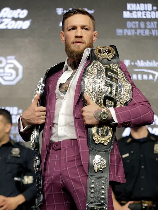 Petarung MMA Conor McGregor berpose dengan memperlihatkan dua sabuk miliknya jelang konferensi pers di New York, AS (20/9). McGregor akan melawan Khabib Nurmagomedov di UFC setelah absen selama dua tahun. (AP Photo/Seth Wenig)