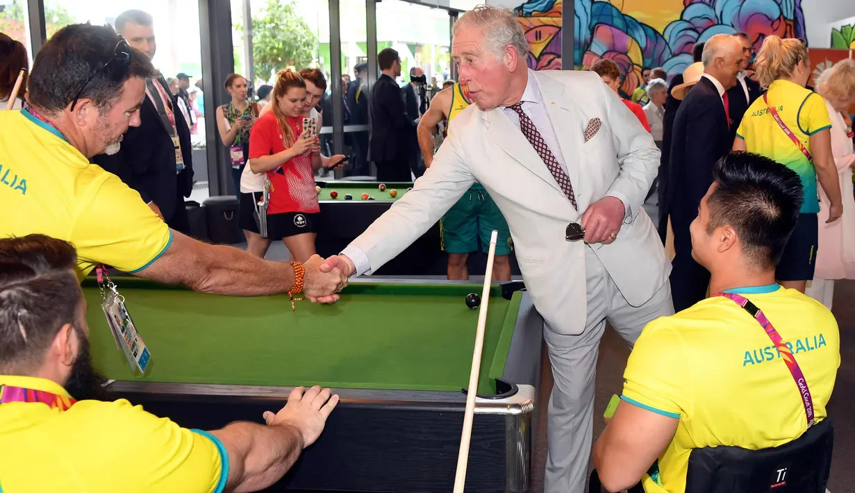 Pangeran Charles (kanan) berjabat tangan dengan anggota tim Australia selama kunjungan ke desa atlet Goldwe Commonwealth Games 2018 di Gold Coast (5/4). (AFP Photo/Pool/William West)