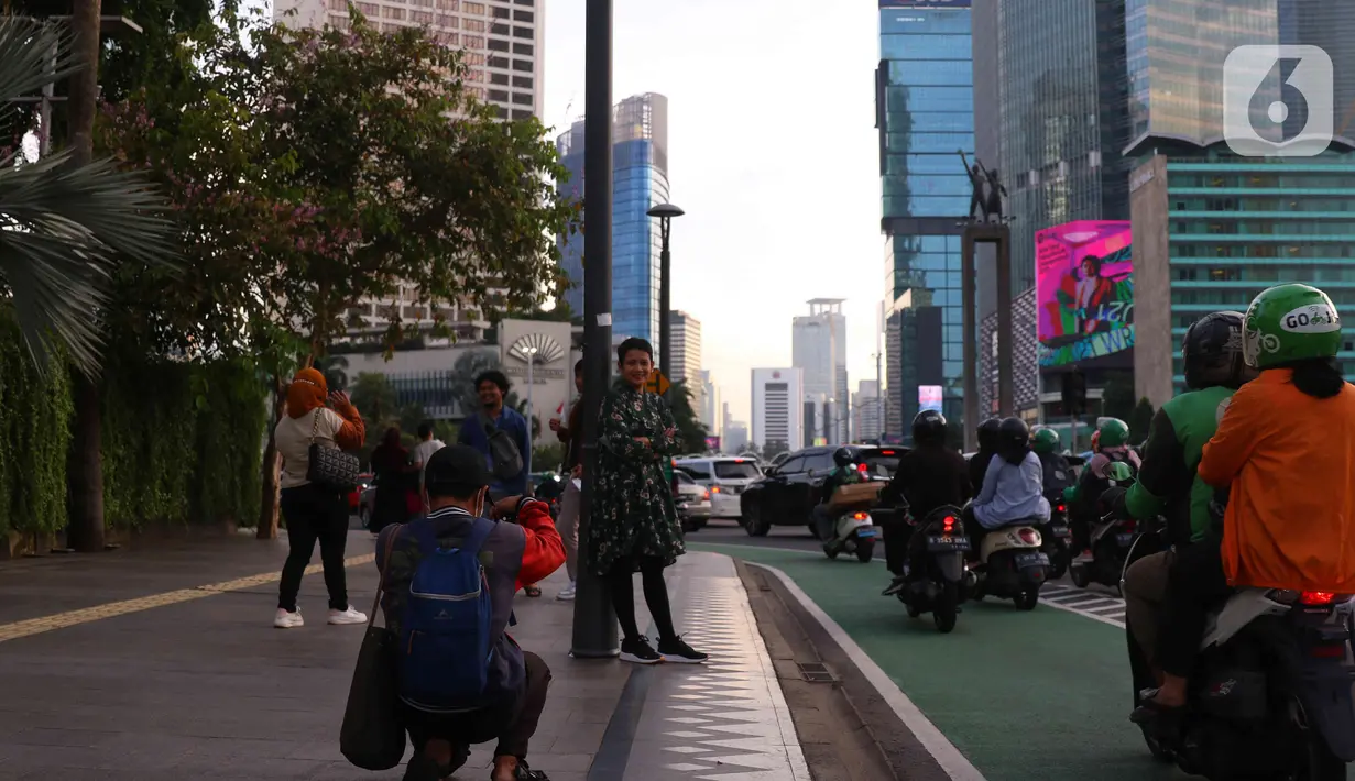 Aktivitas warga saat berada di kawasan Bundaran HI, Jakarta, Jumat (31/12/2021). Polda Metro Jaya melarang perayaan malam tahun baru 2022 di seluruh wilayah DKI Jakarta. Kebijakan itu berlaku mulai 31 Desember 2021 hingga 2 Januari 2022. (Liputan6.com/Angga Yuniar)