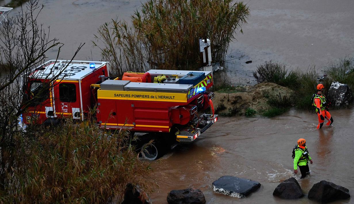 Otoritas cuaca Prancis (Meteo-France) telah mengeluarkan peringatan merah untuk risiko banjir di wilayah Herault. Tampak dalam foto, petugas penyelamat berjalan di sepanjang sungai Herault yang meluap setelah hujan lebat di Agde, Prancis selatan pada Selasa 23 Desember 2025. (Sylvain THOMAS/AFP)
