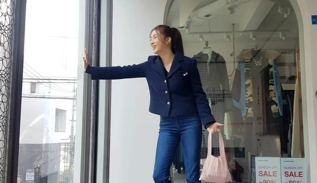 Gaya elegan Kang Sora dibalut jaket biru navy dengan kancing emas, dipadu dengan celana jeans, dan sneakers hitam. [Foto: Instagram/reveramess_]