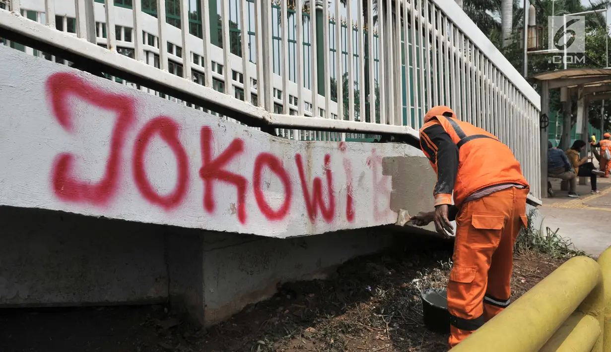 Petugas PPSU mengecat coretan yang mengotori tembok di kawasan Gedung DPR, Jakarta, Rabu (25/9/2019). Demonstrasi mahasiswa yang berujung ricuh yang berujung kerusuhan tersebut menyebabkan fasilitas umum rusak dan penuh coretan yang dibuat oleh pendemo. (merdeka.com/Iqbal S Nugroho)
