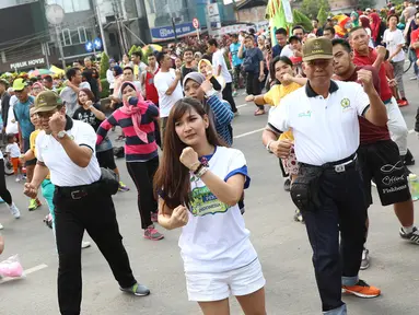 Peserta mengikuti kegiatan body combat dalam acara sosialisasi bertajuk karnaval pekerja di area Car Free Day (CFD) Jalan Jenderal Sudirman, Jakarta Pusat, Minggu (14/5). (Liputan6.com/Immanuel Antonius)