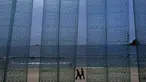 Dua pria terlihat dari tirai plastik sebuah restoran berjalan di pantai Sijung Ho di Korea Utara (14/7/2019). Pantai Sijung Ho merupakan tujuan wisata populer bagi penduduk lokal dan asing. (AP Photo/Vincent Yu)