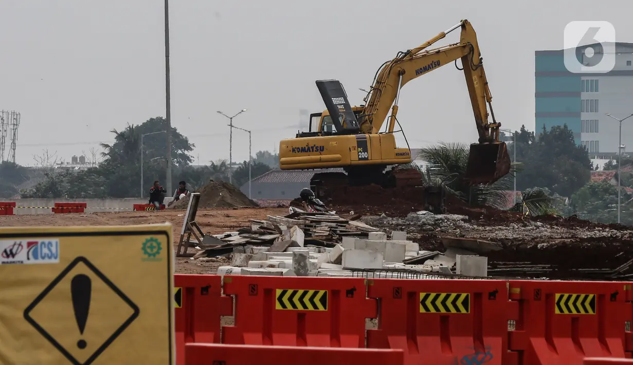 Aktivitas pekerja di depan pintu Tol Pamulang di Tangerang Selatan, Banten, (17/2/2021). Kementerian Pekerjaan Umum dan Perumahan Rakyat melalui Badan Pengatur Jalan Tol (BPJT) mengungkapkan progres konstruksi jalan Tol Serpong-Cinere tersebut sudah mencapai 92,81 persen. Liputan6.com/Johan Tallo)