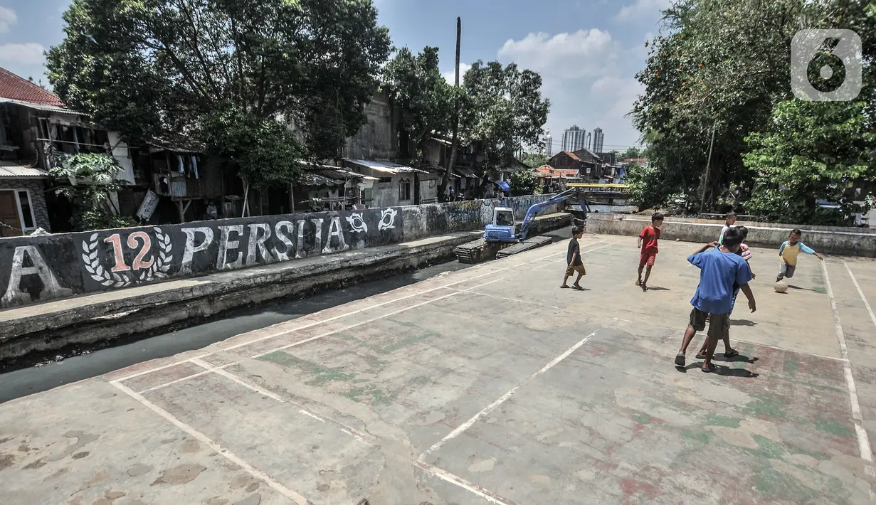 Anak-anak bermain di sekitar Kali Sentiong, Kecamatan Johar Baru, Rabu (22/9/2021). Pengerukan lumpur ini merupakan bagian dari program normalisasi guna memperdalam aliran Kali Sentiong. (merdeka.com/Iqbal S. Nugroho)