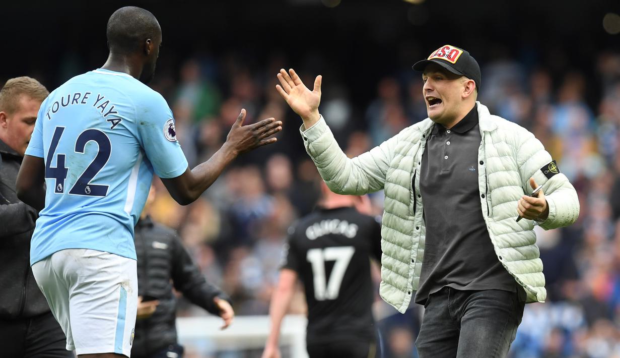 Seorang fans memberikan salam kepada pemain Manchester City, Yaya Toure saat turun ke lapangan Etihad Stadium, Manchester, (22/4/2018). Manchester City menang 5-0. (AFP/Paul Ellis)
