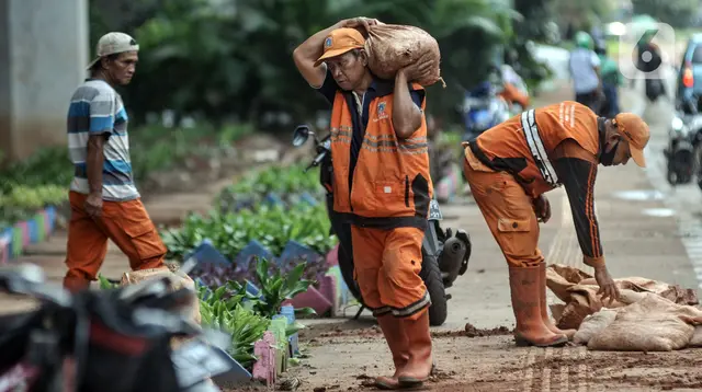 Petugas penanganan prasarana dan sarana umum (PPSU) Kelurahan Cipinang Besar Selatan saat menyelesaikan pembuatan taman di Jalan DI Panjaitan, Jakarta Timur, Rabu (14/12/2022). Berdasarkan data Badan Kepegawaian Daerah (BKD) DKI melalui e-PJLP, jumlah petugas di DKI Jakarta hingga saat ini mencapai 85.310 orang. (merdeka.com/Iqbal S. Nugroho)