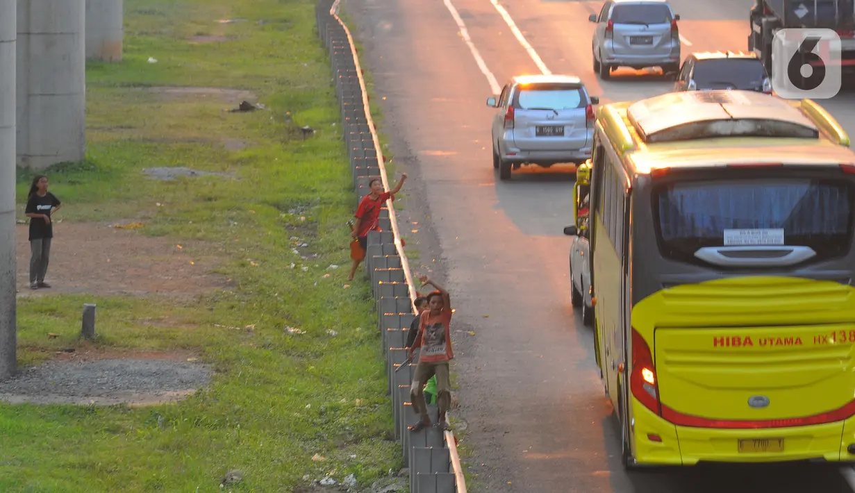 Mereka melambaikan tangan untuk mendapat balasan sambutan klakson telolet pada bus yang melintas di ruas jalan tol Jakarta-Cikampek. (merdeka.com/imam buhori)