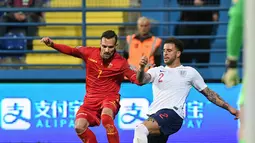 Marko Vesovic mencoba melewati pemain Inggris, Kyle Walker pada laga kedua Kualifikasi Piala Eropa 2020 yang berlangsung di Stadion Pod Goricom, Podgrica, Selasa (26/3). Timnas Inggris menang 5-1 atas Montenegro. (AFP/Savo Prelevic)