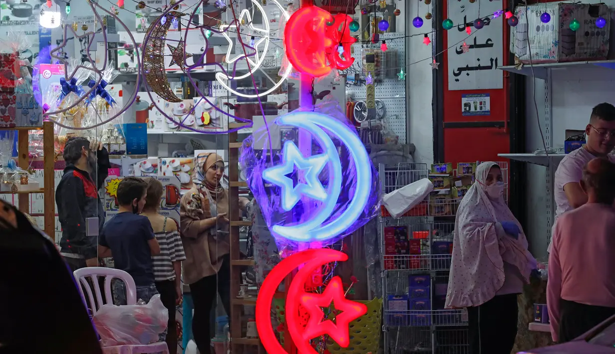 Orang-orang Palestina melihat toko yang menjual lampu hias ketika umat Muslim bersiap untuk memulai bulan suci Ramadan di Yerusalem timur, pada 21 April 2020. Beberapa jalanan di kota Yerusalem akan dihiasi dengan warna-warni lampu dan lentera untuk menyambut datangnya Ramadan. (Ahmad GHARABLI/AFP)