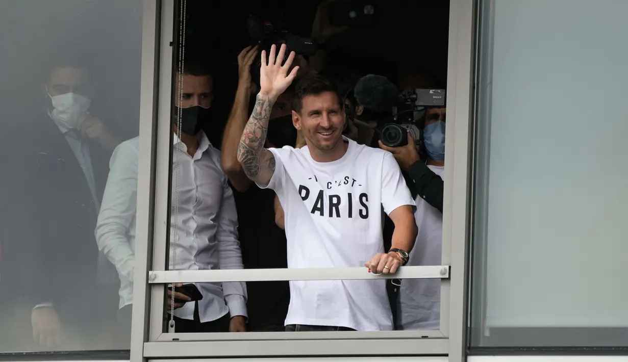 Saat tiba di Bandara Le Bourget, Paris, raut wajah Messi tidak seperti dua hari sebelumnya saat mengucapkan perpisahan dengan Barcelona. Ia pun menyempatkan diri menyapa penggemar dari jendela bandara sambil melambaikan tangan dan juga senyuman. (Foto: AP/Francois Mori)
