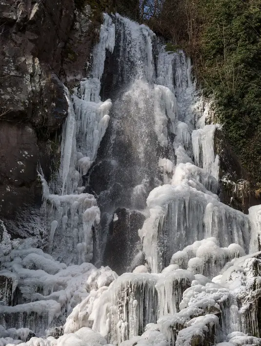 Suasana air terjun  Nideck yang membeku di Oberhaslach, Prancis timur (27/2). Cuaca dingin di Siberia yang dijuluki "The Beast from the East" membuat suhu di sebagian Eropa menurun. (AFP Photo/Patrick Hertzog)